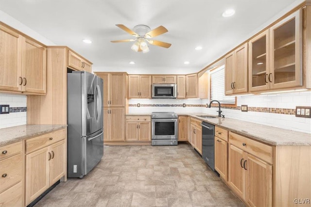 kitchen featuring light stone counters, stainless steel appliances, ceiling fan, sink, and light brown cabinets