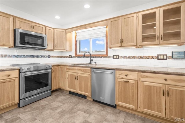 kitchen featuring light brown cabinets, sink, light stone countertops, tasteful backsplash, and stainless steel appliances