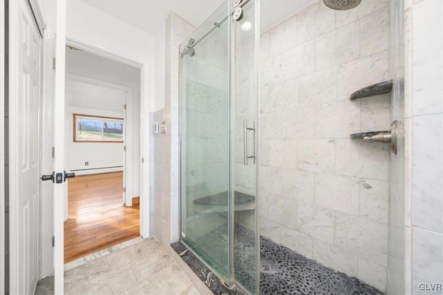 bathroom featuring wood-type flooring, baseboard heating, and a shower with shower door