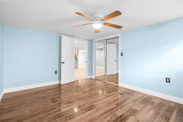 unfurnished bedroom with ceiling fan, a closet, and dark hardwood / wood-style floors