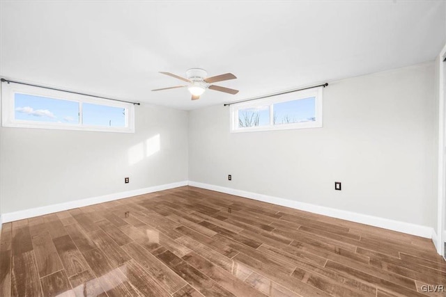 empty room with hardwood / wood-style floors and ceiling fan