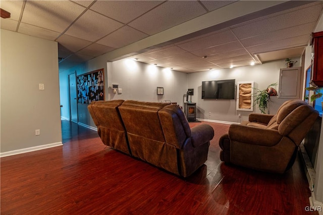 living room featuring a paneled ceiling and dark hardwood / wood-style floors