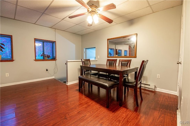 dining space with hardwood / wood-style floors, a paneled ceiling, ceiling fan, and baseboard heating