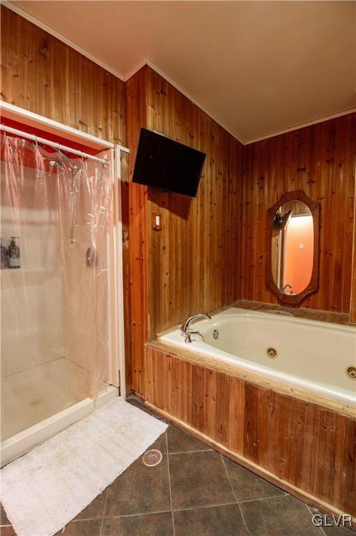 bathroom featuring tile patterned flooring, a bath, and wooden walls