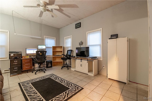 tiled office space featuring baseboard heating, ceiling fan, and a textured ceiling