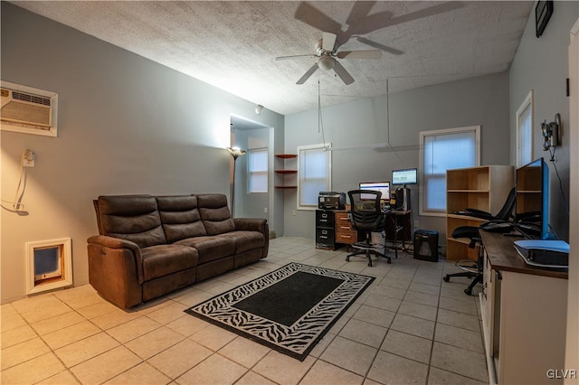 tiled office featuring a wall unit AC, ceiling fan, and a textured ceiling