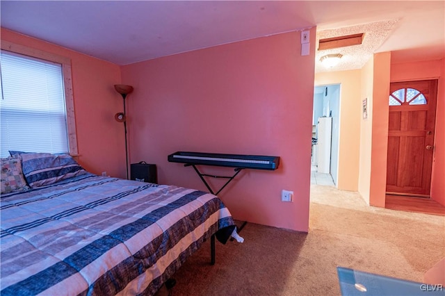 bedroom featuring white refrigerator and light carpet