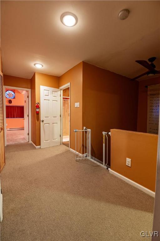 hallway with carpet and a baseboard heating unit