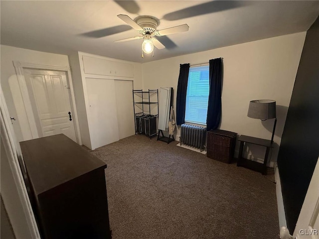 carpeted bedroom with radiator, ceiling fan, and a closet