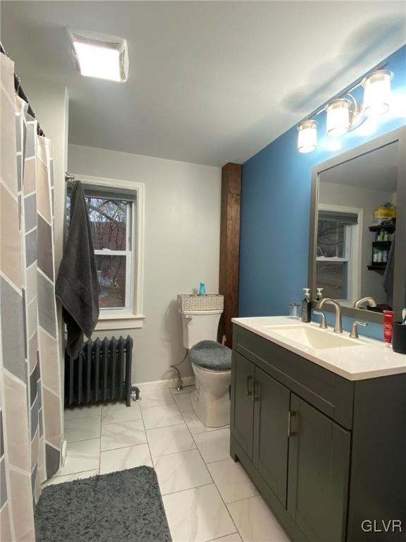 bathroom with tile patterned floors, vanity, toilet, and radiator