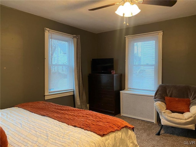 carpeted bedroom with radiator heating unit and ceiling fan