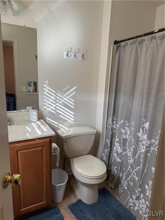 bathroom with tile patterned flooring, vanity, and toilet