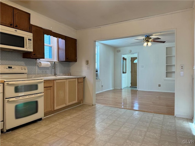 kitchen with white appliances, sink, decorative backsplash, ceiling fan, and light wood-type flooring