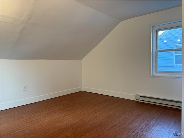 bonus room featuring dark wood-type flooring, lofted ceiling, and a baseboard heating unit