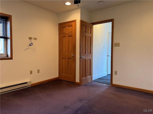 unfurnished room with dark colored carpet and a baseboard radiator