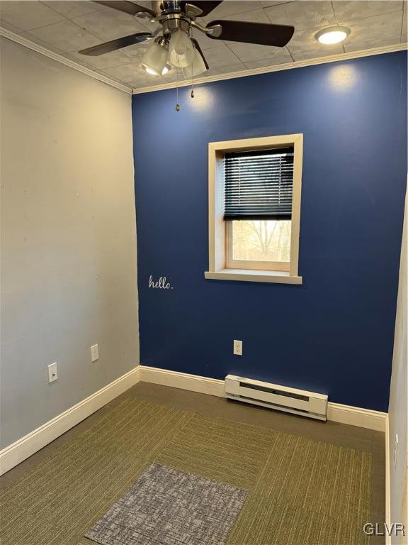 carpeted empty room featuring baseboard heating, crown molding, and ceiling fan