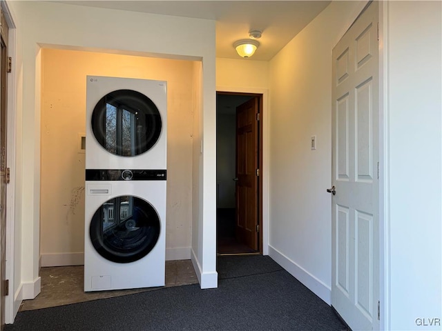 washroom with dark colored carpet and stacked washer and clothes dryer