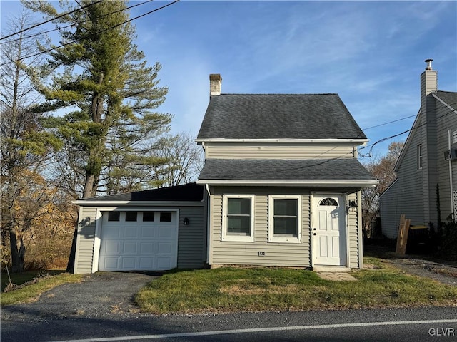 view of front of property featuring a garage and a front lawn