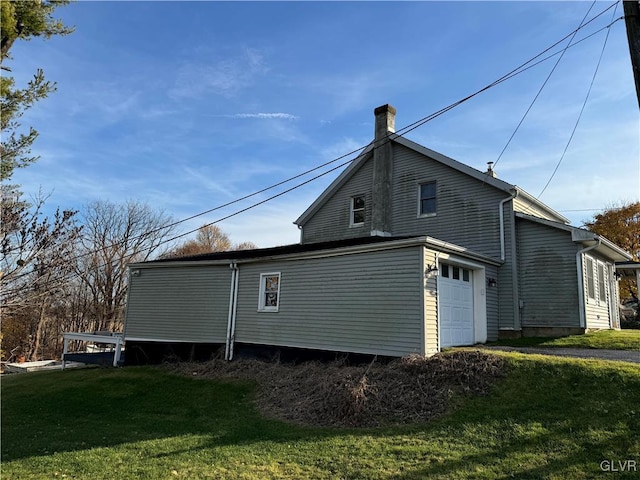 view of side of home with a lawn and a garage