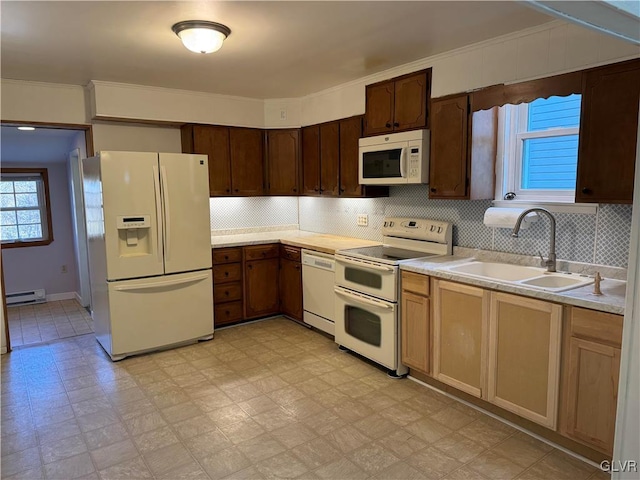 kitchen with tasteful backsplash, white appliances, baseboard heating, crown molding, and sink