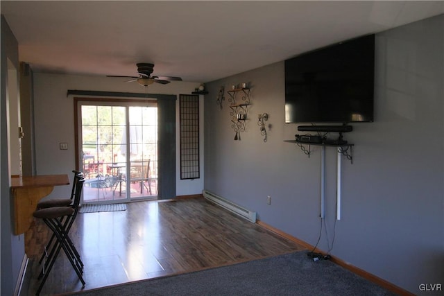 unfurnished living room featuring wood-type flooring, a baseboard radiator, and ceiling fan