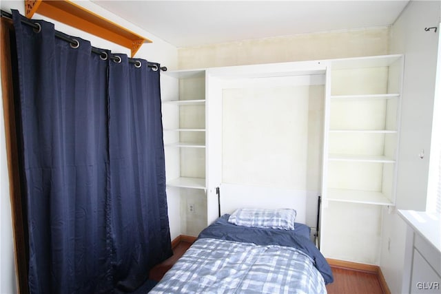 bedroom with dark hardwood / wood-style flooring