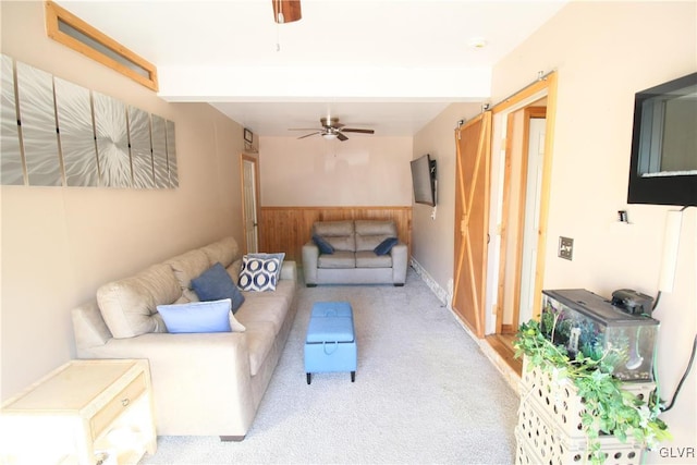 living room with ceiling fan, beamed ceiling, and light carpet