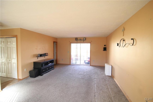 unfurnished living room with carpet flooring and radiator heating unit