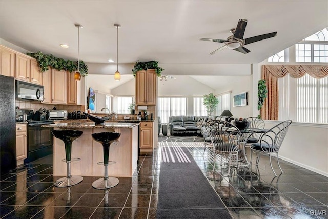 kitchen featuring ceiling fan, light brown cabinets, a kitchen breakfast bar, pendant lighting, and black appliances