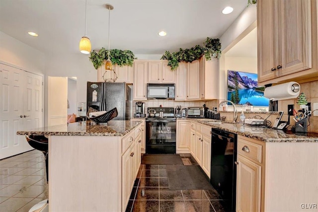 kitchen featuring pendant lighting, black appliances, decorative backsplash, light stone counters, and a kitchen bar