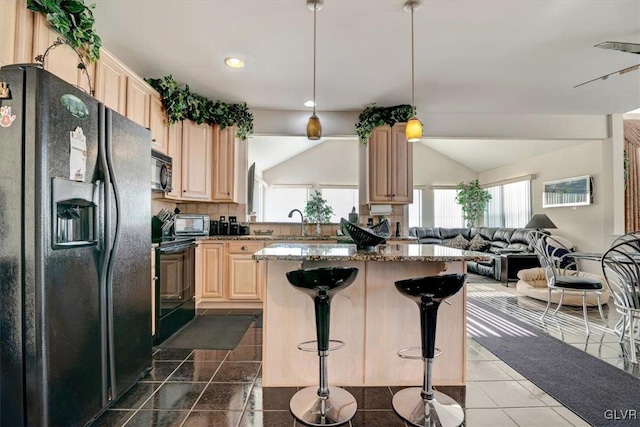 kitchen featuring light brown cabinets, hanging light fixtures, stone countertops, a kitchen bar, and black appliances