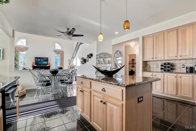 kitchen with light brown cabinets, dark stone counters, and decorative light fixtures