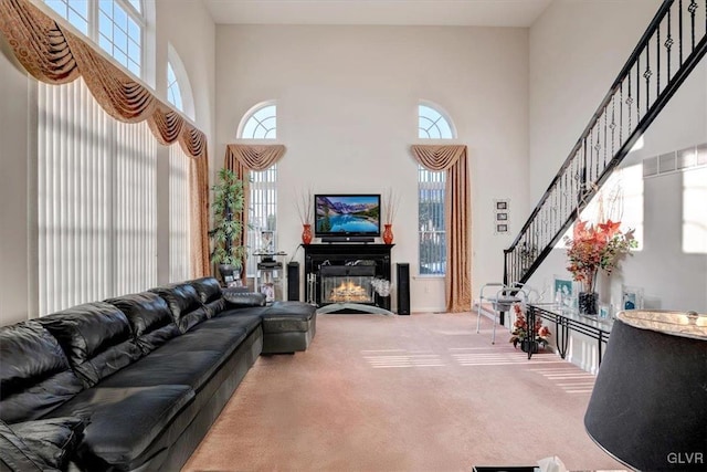 carpeted living room with a towering ceiling