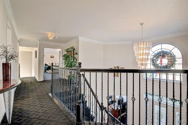 corridor featuring ornamental molding, dark carpet, and a notable chandelier