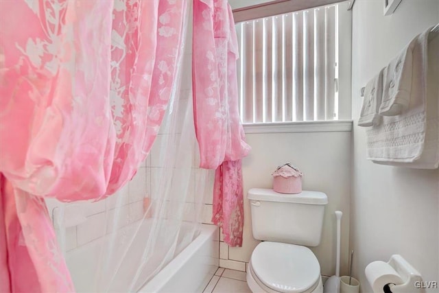 bathroom with tile patterned floors, shower / bath combination with curtain, and toilet