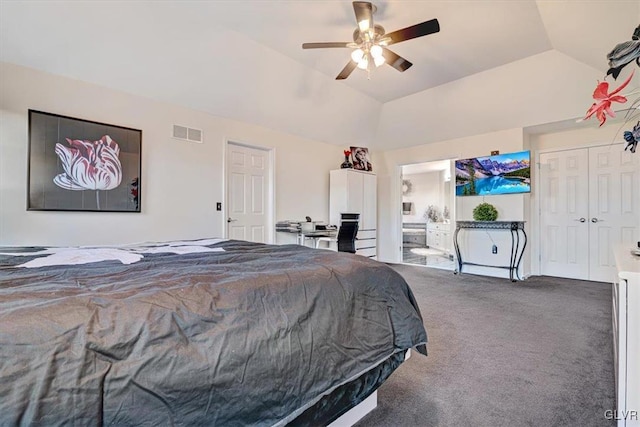 bedroom featuring ceiling fan, ensuite bathroom, carpet floors, lofted ceiling, and a closet