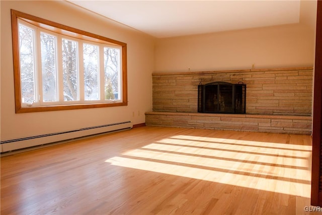 unfurnished living room with baseboard heating, a fireplace, and wood-type flooring