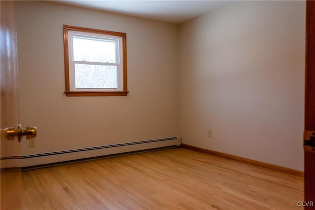 spare room with baseboard heating and light wood-type flooring