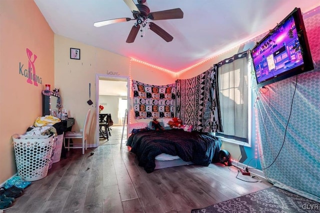 bedroom featuring ceiling fan, hardwood / wood-style floors, and lofted ceiling