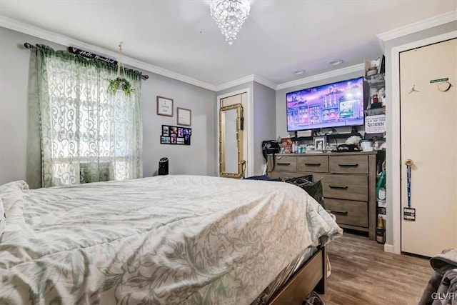 bedroom with hardwood / wood-style floors, a chandelier, and ornamental molding