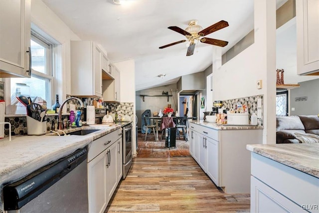 kitchen with white cabinets, appliances with stainless steel finishes, light hardwood / wood-style floors, and sink