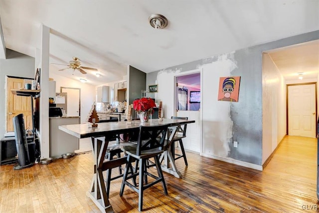 dining room featuring hardwood / wood-style floors, ceiling fan, and vaulted ceiling