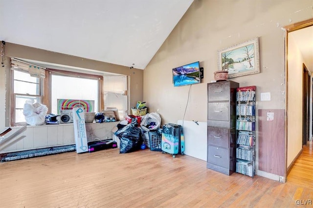 misc room with high vaulted ceiling and light wood-type flooring