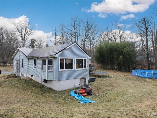 view of property exterior featuring a lawn and a trampoline