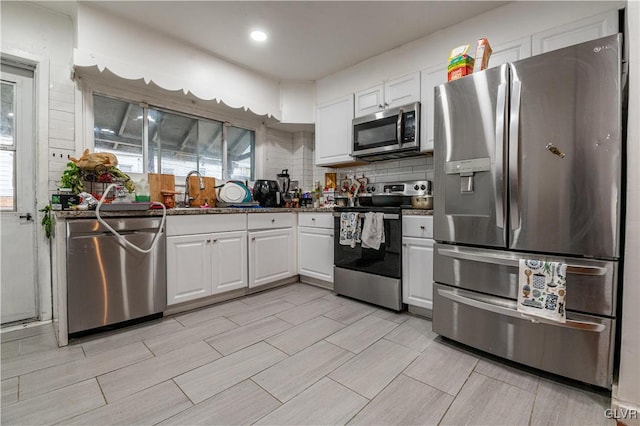 kitchen with white cabinets, sink, backsplash, and appliances with stainless steel finishes