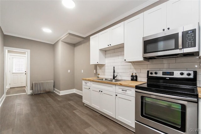 kitchen featuring radiator, white cabinetry, sink, wooden counters, and appliances with stainless steel finishes