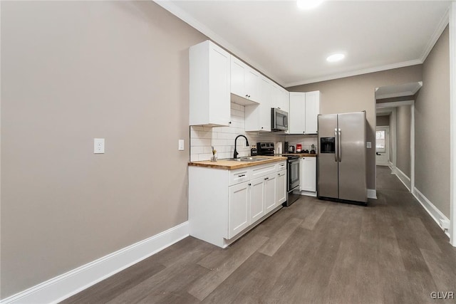 kitchen with butcher block counters, sink, appliances with stainless steel finishes, dark hardwood / wood-style flooring, and white cabinetry