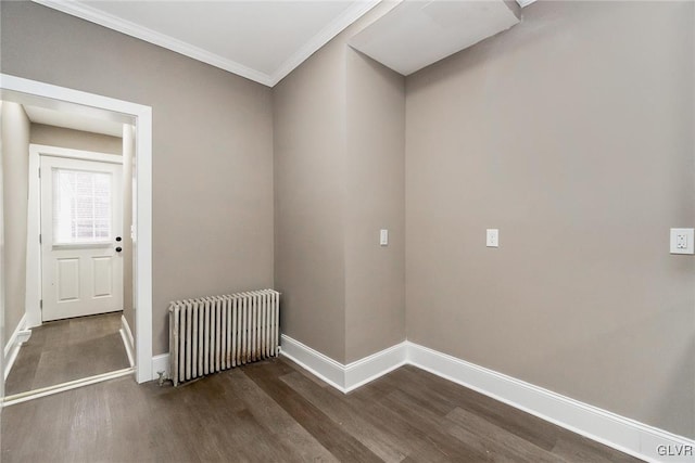 spare room with radiator, dark hardwood / wood-style floors, and ornamental molding