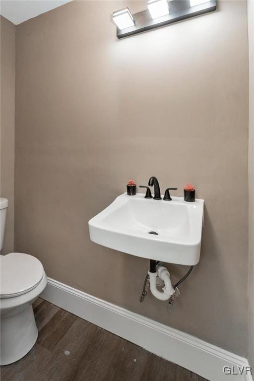 bathroom with hardwood / wood-style flooring and toilet