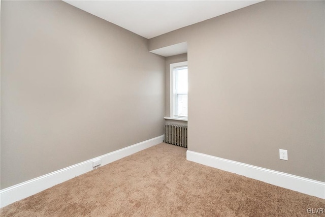 carpeted spare room featuring radiator heating unit